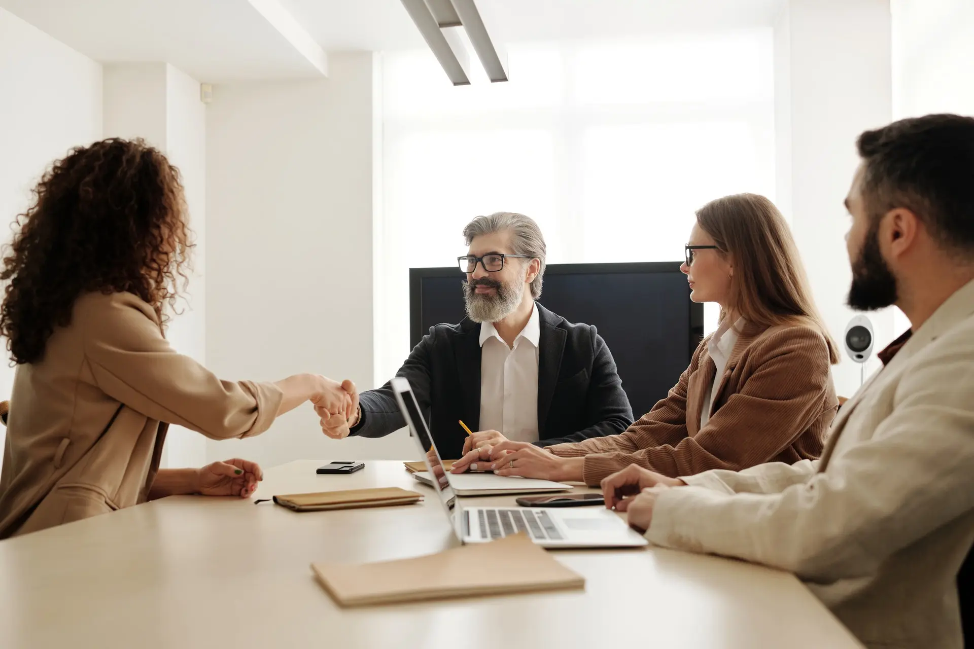 Woman shakes man hand during the meeting at the table