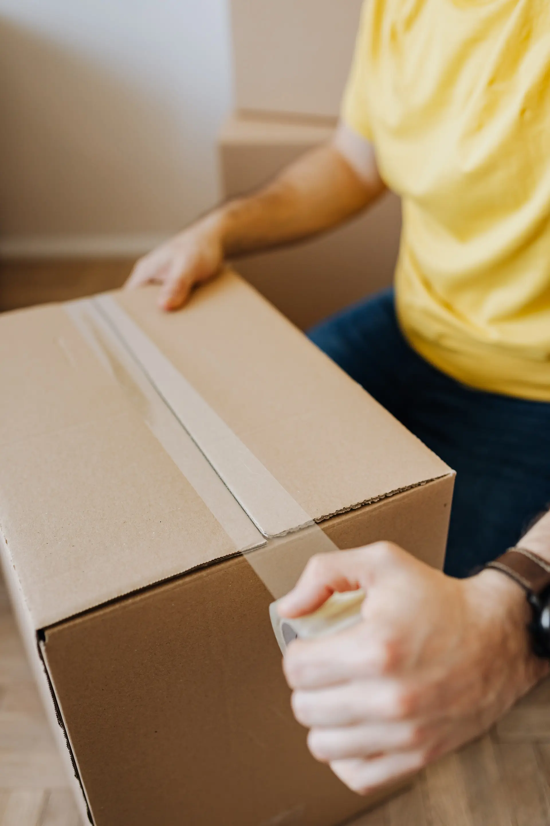 Person tapes a devlivery box